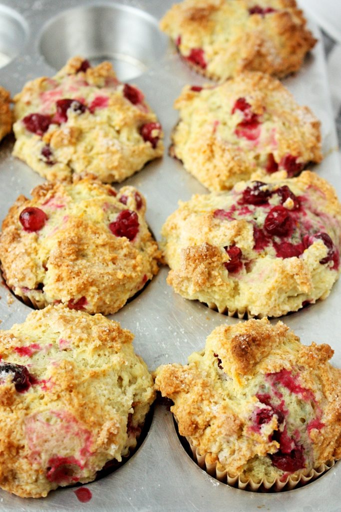 The Best Orange Cranberry Muffins || A perfect blend of sweet orange, vanilla flavor and cranberry tartness, packed into a wonderfully dense, chewy, crispy-topped muffin. Made with the zest of one navel orange, frozen cranberries, melted butter, and sour cream. #mondaysundaykitchen #orangecranberrymuffins #bestorangecranberrymuffinsrecipe #bestmuffinrecipes #orangemuffins #cranberrymuffins #cranberryrecipes #orangerecipes #muffinrecipes 
