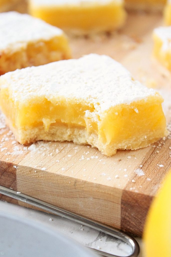 Close up of a bite taken out of these yummy lemon squares.