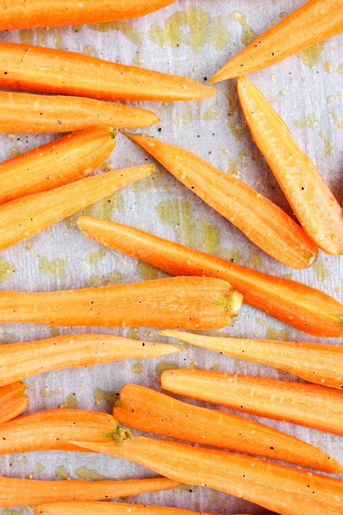 Carrots drizzled with olive oil, salt and pepper and ready for roasting.