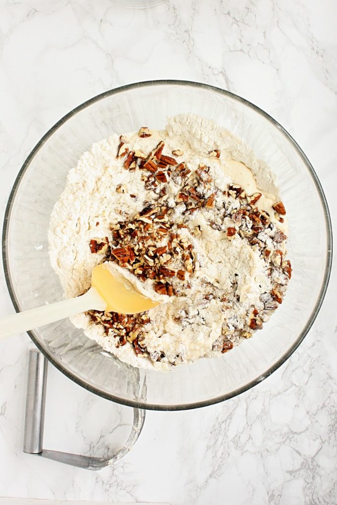 Mixing flour, pecans, sour cream, vanilla, and maple in a mixing bowl