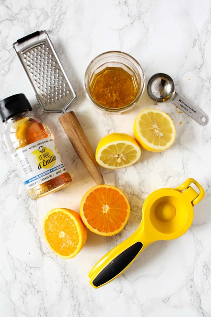 Citrus dressing ingredients: fresh orange, lemon, honey, and olive oil.